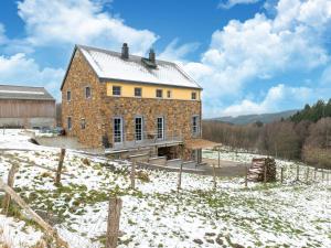 una gran casa de ladrillo en un campo en la nieve en Magnificent accommodation for 15 people, en Trois-Ponts