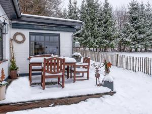 uma casa com uma mesa e cadeiras na neve em Charming house with sauna and Nordic bath em Bullange