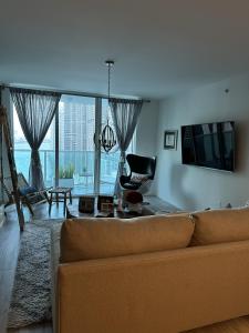 een woonkamer met een bank en een groot raam bij BRICKELL in Miami