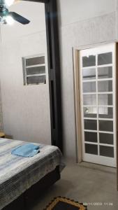ein Schlafzimmer mit einem Bett und eine Tür mit einem Fenster in der Unterkunft Hospedagem Em Santana de Parnaíba in Santana de Parnaíba