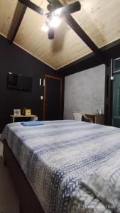 een slaapkamer met een bed en een plafondventilator bij Hospedagem Em Santana de Parnaíba in Santana de Parnaíba