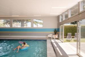 two women playing in a swimming pool in a house at Port Fairy Holiday Park in Port Fairy