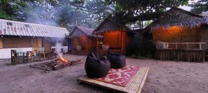 a group of huts with a fire in front of it at Little Beach Garden in Ban Ai Dao