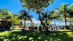 een park met palmbomen en uitzicht op de oceaan bij La Concepcion Cove Garden Resort in Moalboal