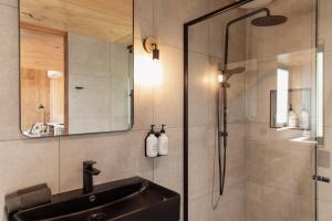 W łazience znajduje się umywalka i prysznic. w obiekcie Bicheno Garden Cottages w mieście Bicheno