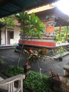 een bank voor een gebouw met enkele planten bij Artawa House in Ubud