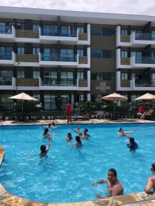 eine Gruppe von Personen in einem Schwimmbad in einem Hotel in der Unterkunft Mana Beach Experience -02Garagens - Aloha 001 in Ipojuca