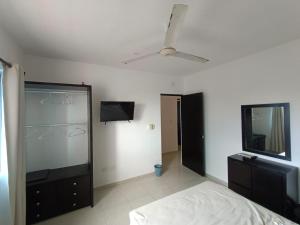 um quarto com uma cama e uma televisão de ecrã plano em Casa colibri. em Progreso