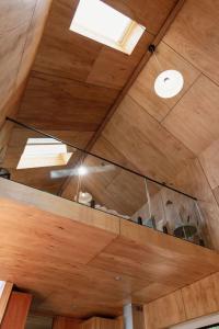 ビチェノにあるBicheno Garden Cottagesの窓付きの木製天井の客室です。