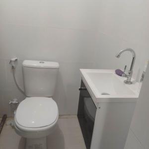 ein Badezimmer mit einer weißen Toilette und einem Waschbecken in der Unterkunft Casa com piscina em Guarajuba 4quartos in Camassari
