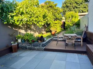 een patio met een tafel, stoelen en planten bij Lovely Victorian Terrace - Entire home in Melbourne