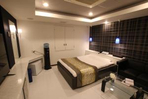 1 dormitorio con 1 cama y 1 sofá en una habitación en K-WAVE, en Kasukabe