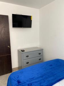 sypialnia z łóżkiem i telewizorem na ścianie w obiekcie Apartamentos Magallanes Romana w mieście La Romana