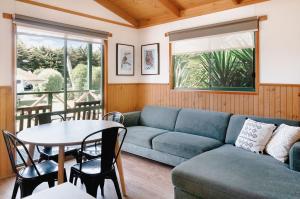 a living room with a blue couch and a table at Port Fairy Holiday Park in Port Fairy