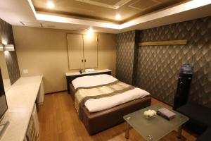 KasukabeHOTEL K-WAVE Adult Only的一间有一张床和一张桌子的小房间