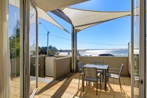 a balcony with a table and chairs and a view of the beach at Sandcastle Apartments in Port Macquarie