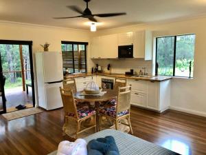 a kitchen with a table and a refrigerator at The Bungalow - Luxurious & Calm - Beach and Bush Retreat in Valla Beach