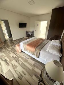 1 dormitorio con 1 cama y 1 mesa con lámpara en Pousada Moriah 700 metrôs Magic City, en Suzano