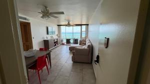 a living room with a table and a living room with a ceiling fan at Beach Front Condo in Isla Verde! in San Juan