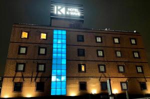 a building with blue lights on the side of it at K-WAVE in Kasukabe