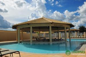 a gazebo on the side of a swimming pool at LACQUA Di'Roma, park 24h, cozinha com fogão, 5 pessoas gG in Caldas Novas