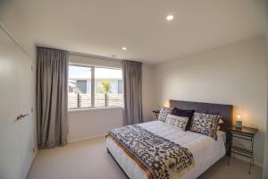um quarto com uma cama grande e uma janela em The Gallery em Rotorua