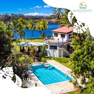 a house with a swimming pool and a view of the water at Quinta El Espino in Ahuachapán