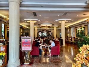 two people sitting at a table in a restaurant at Khách sạn Sa Chi - Móng Cái in Móng Cái