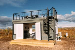 a tiny house with a balcony and a staircase at New Starry Night Shipping Container Home in Alpine
