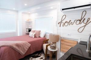 a bedroom with a bed and a sign that reads honey at New Cowgirl Shipping Container Home in Alpine