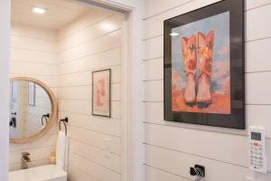 a bathroom with a painting of a cat on the wall at New Cowgirl Shipping Container Home in Alpine
