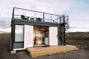 a small house with a balcony and a deck at New Cowgirl Shipping Container Home in Alpine