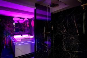 a bathroom with purple lighting and a sink and a shower at Love room “La nuit de rêve” centre historique in Perpignan