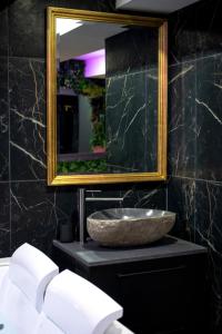a bathroom with a stone sink and a mirror at Love room “La nuit de rêve” centre historique in Perpignan
