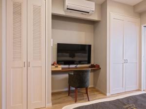 um quarto com uma secretária e uma televisão num quarto em Family Condo Chatan Hills by Coldio Premium em Chatan