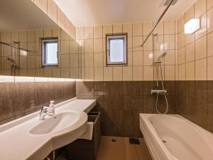 uma casa de banho com um lavatório e uma banheira em Family Condo Chatan Hills by Coldio Premium em Chatan