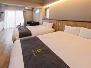 - une chambre d'hôtel avec 2 lits dans l'établissement Family Condo Chatan Hills by Coldio Premium, à Chatan