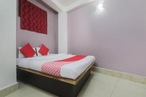 ein Schlafzimmer mit einem Bett mit roten Kissen darauf in der Unterkunft Am Bed And Breakfast in Shillong