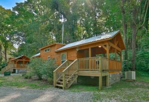 Bryce Cabin Lookout Mtn Tiny Home W Swim Spa في تشاتانوغا: كابينة خشبية كبيرة مع شرفة كبيرة