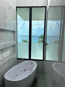 a bathroom with a tub and a window with the ocean at Mansión Casa Bali in San Andrés