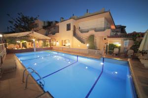 a swimming pool in front of a house at night at Erato Hotel in Kokkini Khanion