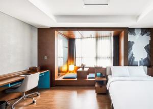 釜山Haeundae Wide Ocean View & Residence的一间卧室，配有一张床、一张桌子和一把椅子