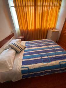パカズマヨにあるHostal Pacasmayo Beachのベッドルーム1室(青と白の毛布付きのベッド1台付)