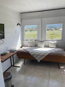 Posto letto in camera con scrivania e 2 finestre. di Complejo KUPAL a Lolog