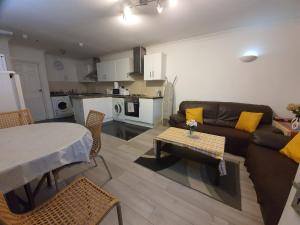 a living room with a couch and a table at Ilford Rooms in Goodmayes