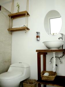 a bathroom with a toilet and a sink and a mirror at Tropic Bacalar in Bacalar