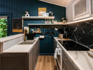 a kitchen with blue walls and a sink at WB Clare Valley Cottage w Loft in Clare