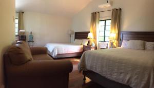 a hotel room with two beds and a couch at Santa Cruz Cabins in Santa Elena