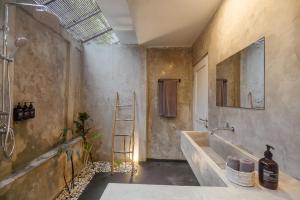 a bathroom with a large sink and a ladder at The Room Padang-Padang in Uluwatu