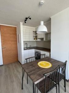 una cocina con una mesa de madera con una placa amarilla. en Departamento La Serena, en La Serena